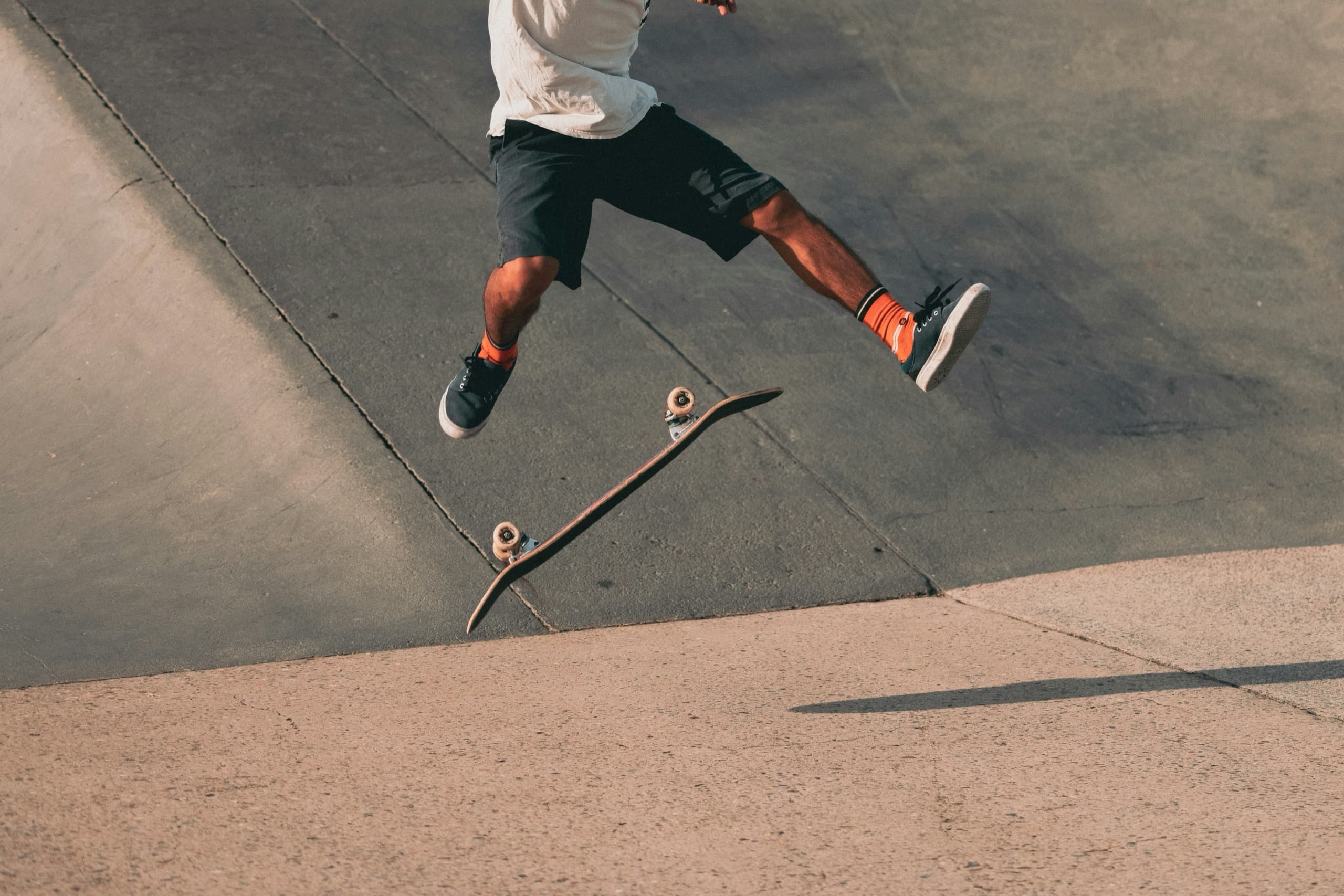 Skater mid-kickflip on a concrete bank