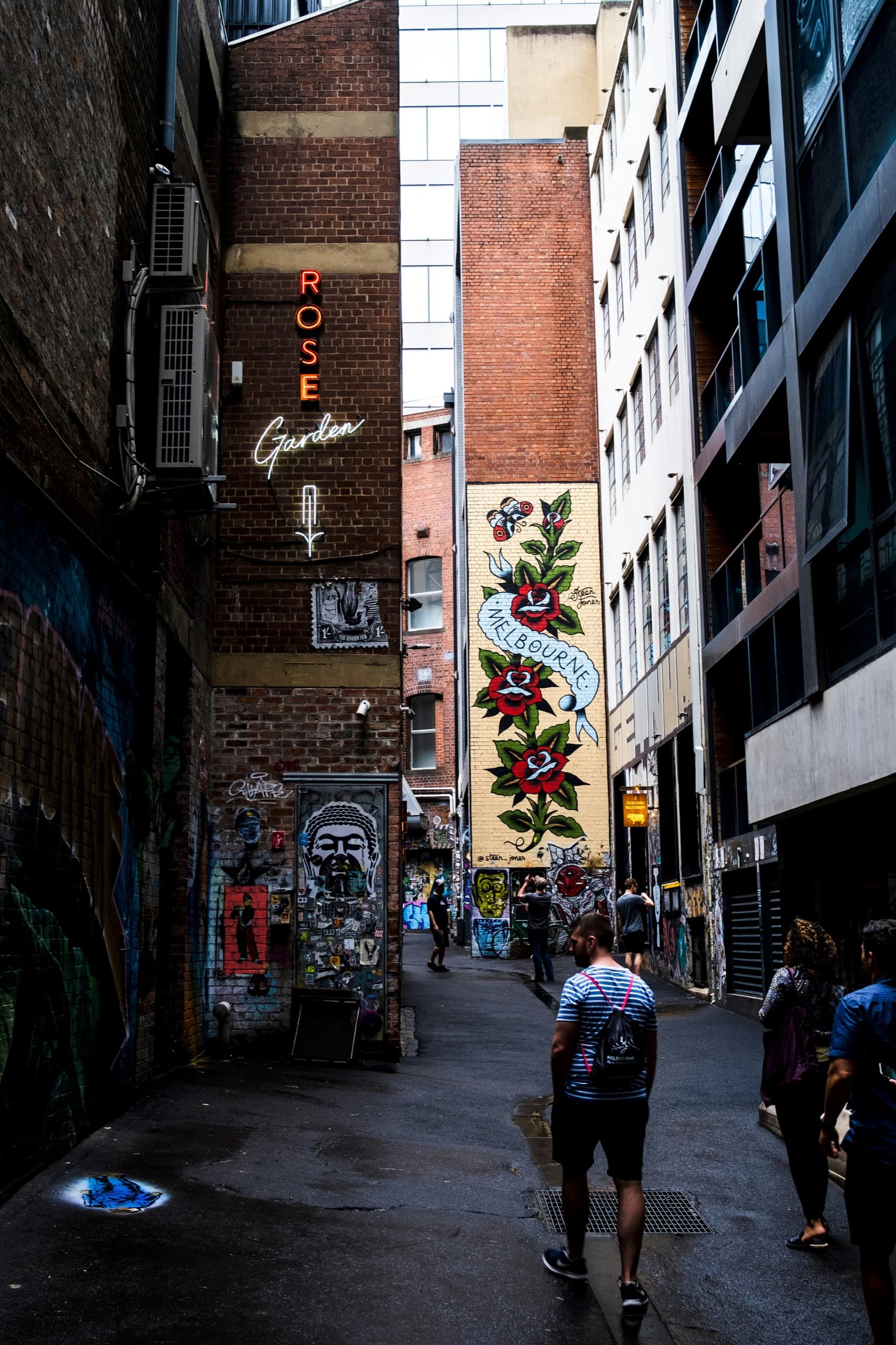 People walking through a Melbourne street-art laneway