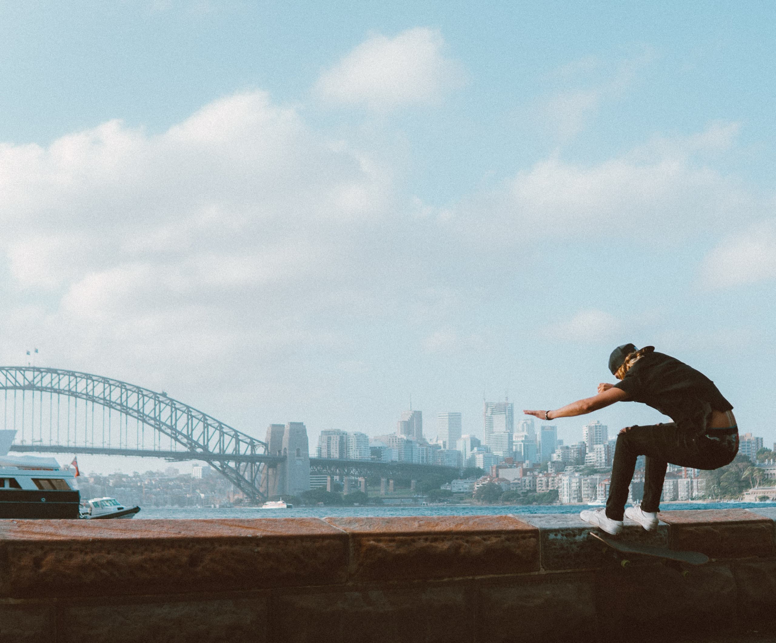 Skater on a ledge with the Sydney Harbour Bridge behind